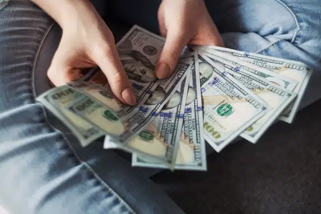 A person counting the loan amount obtained as car title pawn 
