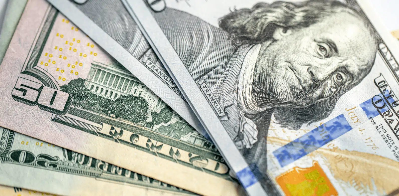 A cheerful couple sits across from an advisor who gestures expressively, with floor plans and a pen on the desk between them