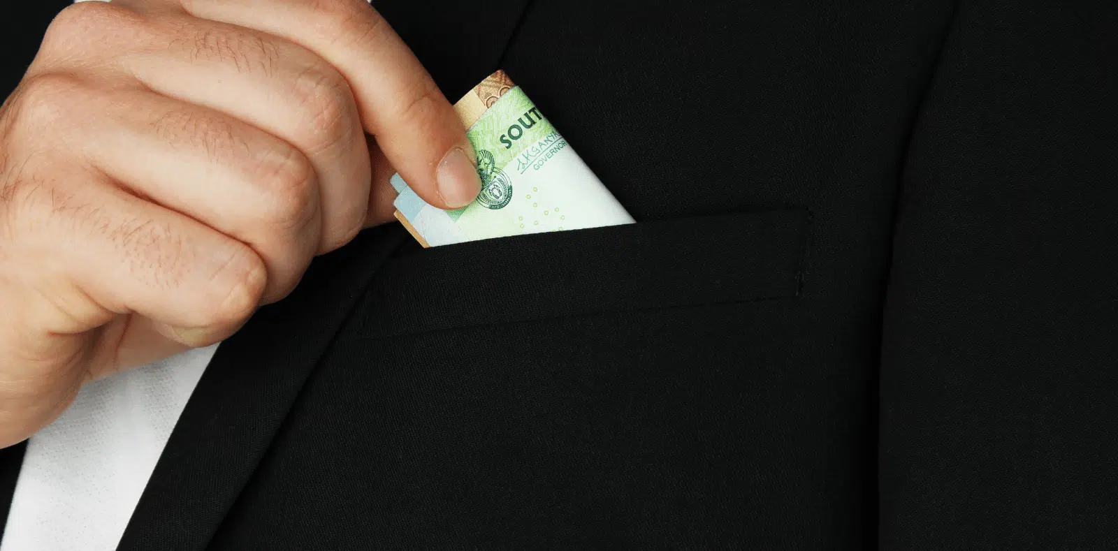 A flat lay of a pink piggy bank, cashbook, house-shaped keychain, keys, pen, calculator, and invoice documents on a wooden desk