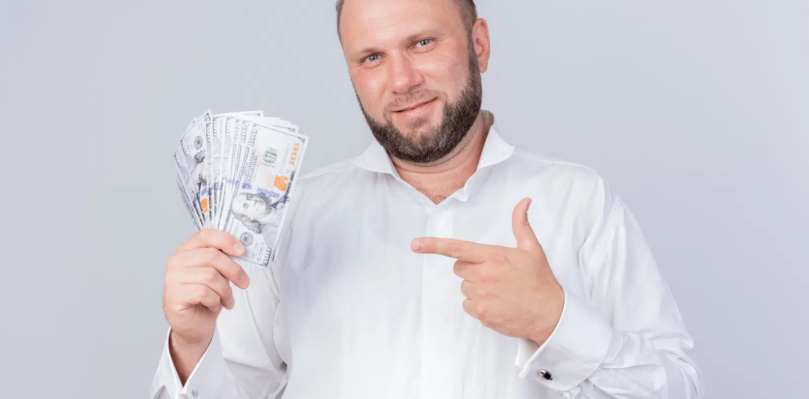 A woman in glasses holds a document while a bearded man leans in to review it alongside a laptop on a marble table in a bright room